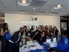 Group of hours college students paired with faculty holding up the yotie hand symbol